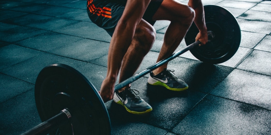 Man squats with weighted barbell